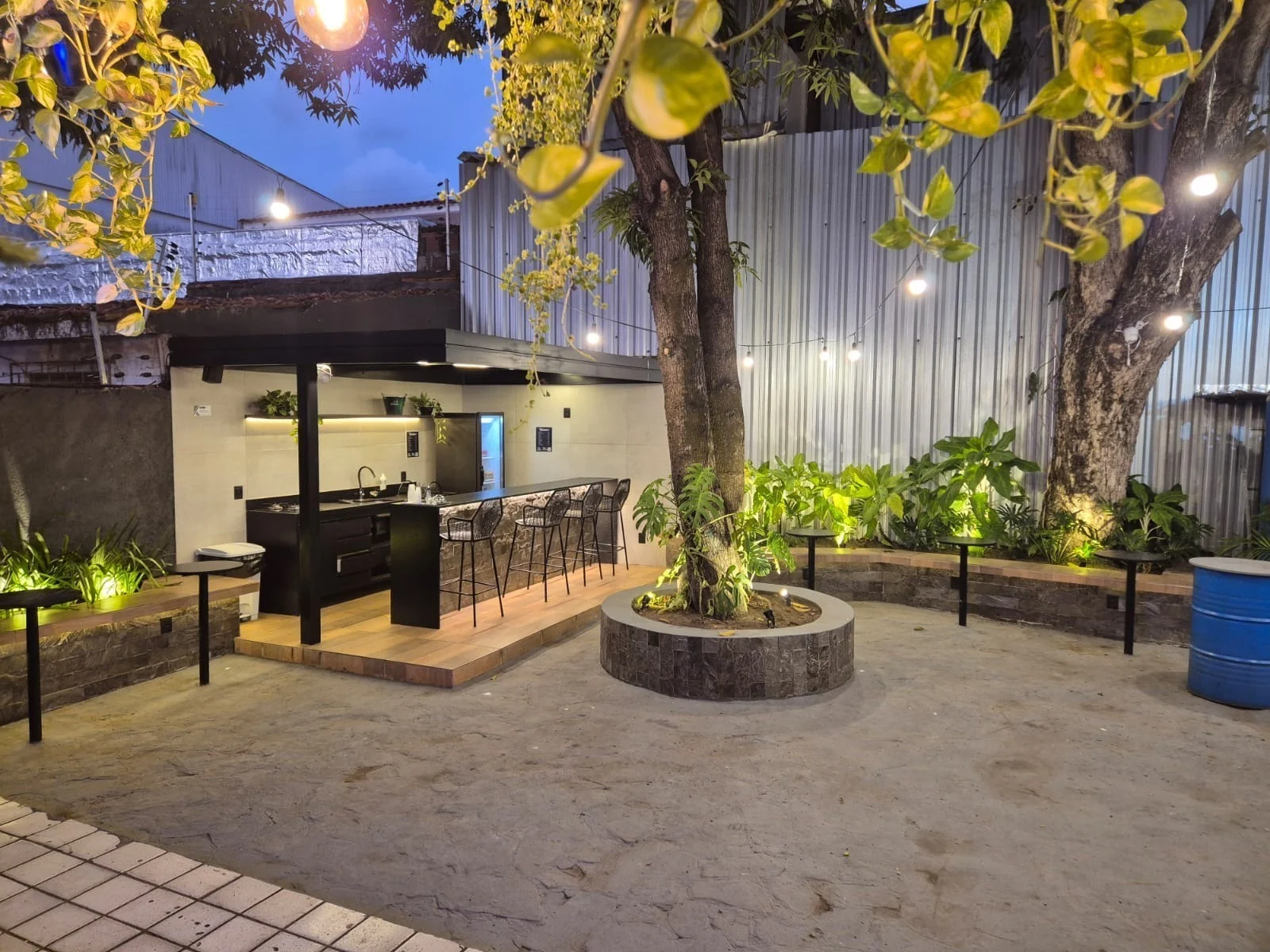 Área de convivência arborizada do Clubjob Manaíra, com iluminação e espaço de apoio